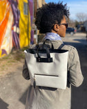 Woman wearing white and black backpack